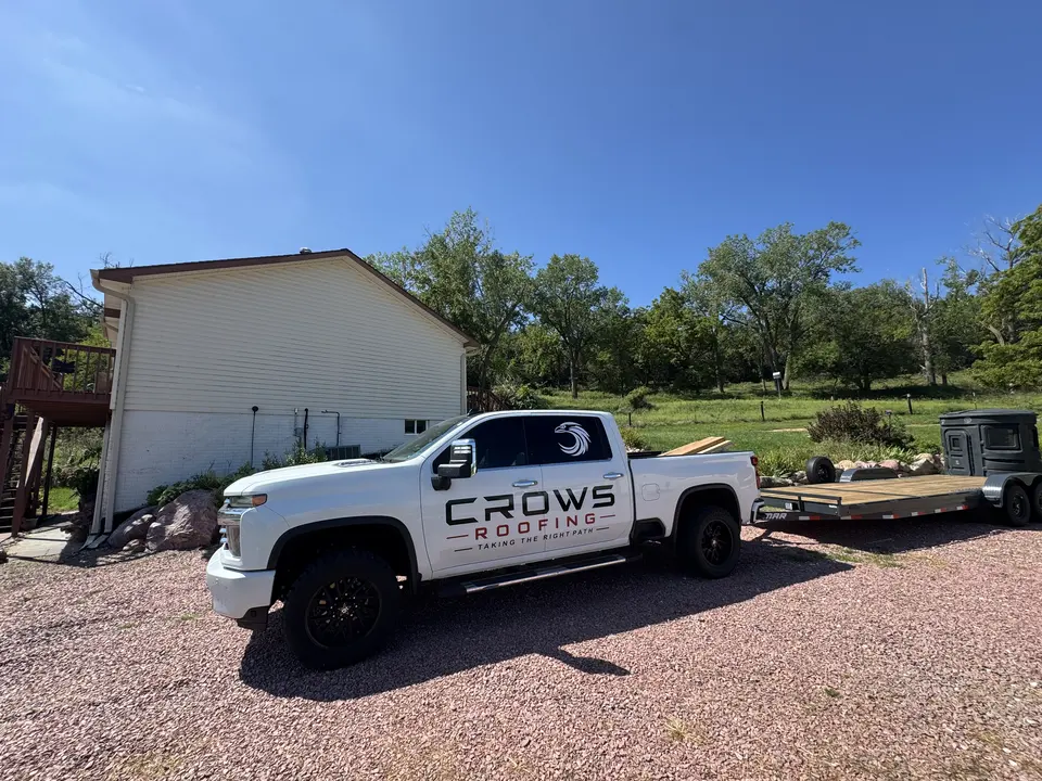 Crows Roofing service truck beside a residential exterior