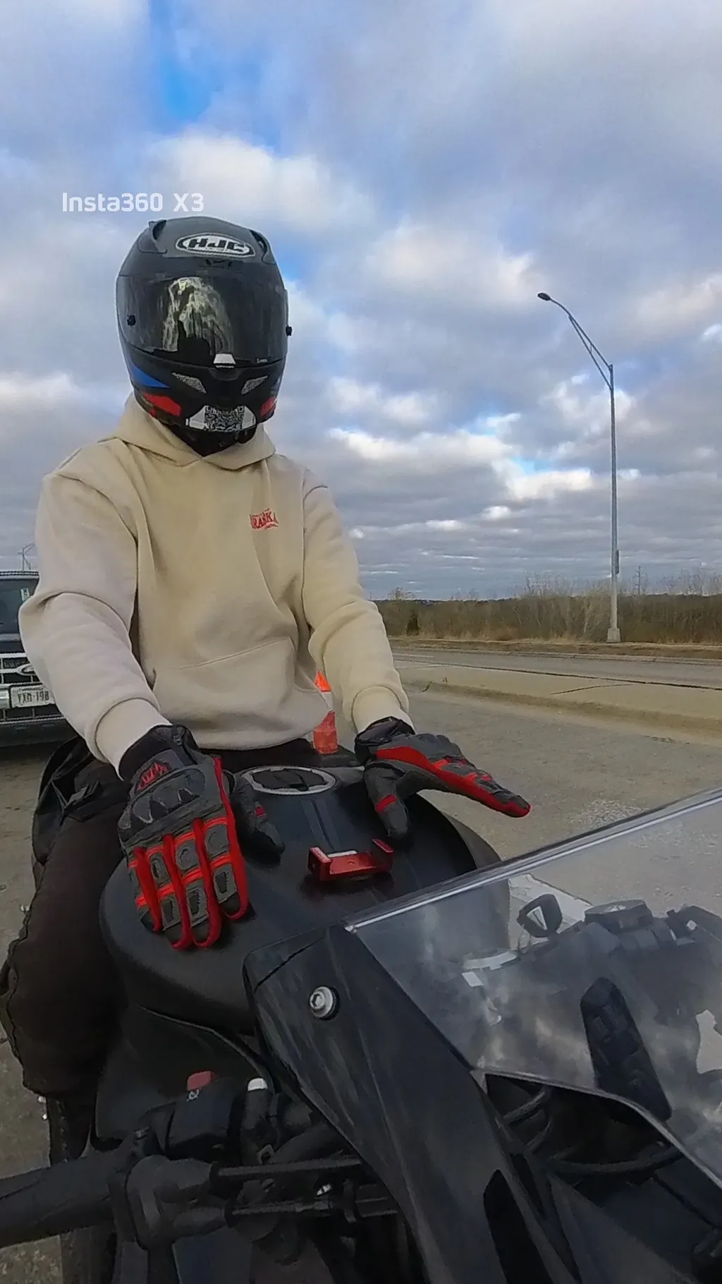 A helmeted rider on a motorcycle in Omaha, Nebraska, beneath a cloudy sky.