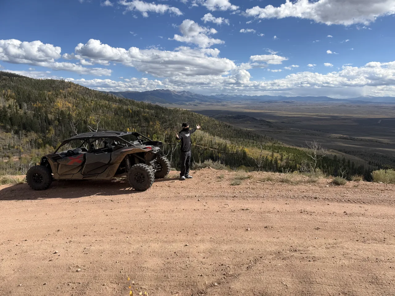 A person beside an off-road vehicle at a mountain overlook in North Sand Hills, Colorado.